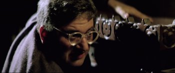 Movie still from “Anguish” (1987), directed by Bigas Luna – An older woman wearing glasses looking at the camera; Close Up shot, Low angle