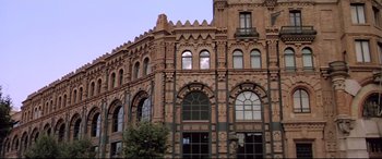 Movie still from “Anguish” (1987), directed by Bigas Luna – A large building with many windows on the outside; Extreme Wide shot, Low angle