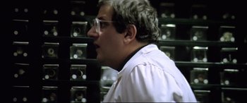 Movie still from “Anguish” (1987), directed by Bigas Luna – A man in a white lab coat is looking at a wall; Close Up shot, Low angle