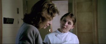Movie still from “Anguish” (1987), directed by Bigas Luna – Two women are talking in front of a mirror; Close Up shot, Over the shoulder angle