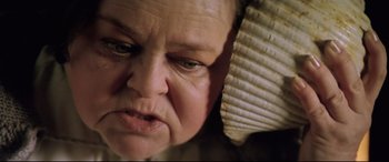 Movie still from “Anguish” (1987), directed by Bigas Luna – An older woman is looking angry at the camera; Extreme Close Up shot, Low angle