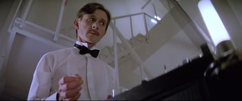 Movie still from “Anguish” (1987), directed by Bigas Luna – A man in a white shirt and a bow tie; Close Up shot, Low angle