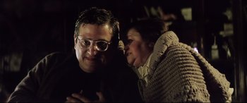 Movie still from “Anguish” (1987), directed by Bigas Luna – A man and a woman sitting next to each other; Close Up shot, Over the shoulder angle