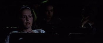 Movie still from “Anguish” (1987), directed by Bigas Luna – A woman sitting in a dark room next to another woman; Close Up shot, Low angle