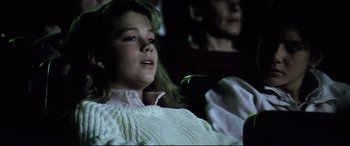 Movie still from “Anguish” (1987), directed by Bigas Luna – A young girl sitting in a chair next to an older woman; Close Up shot, High angle