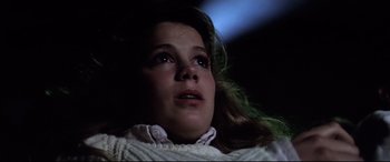 Movie still from “Anguish” (1987), directed by Bigas Luna – A young girl looking up into the air; Close Up shot, Low angle