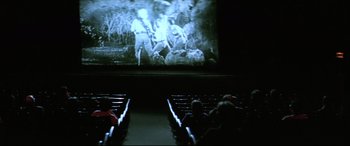 Movie still from “Anguish” (1987), directed by Bigas Luna – People sitting in a movie theater watching a movie; Extreme Wide shot, High angle