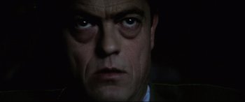 Movie still from “Anguish” (1987), directed by Bigas Luna – A man's face in the dark; Close Up shot, Low angle