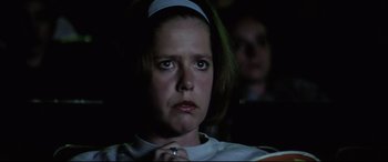 Movie still from “Anguish” (1987), directed by Bigas Luna – A person sitting in front of a projector screen; Close Up shot, Low angle