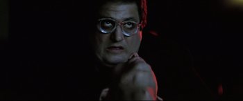Movie still from “Anguish” (1987), directed by Bigas Luna – A man wearing glasses is looking at the camera; Close Up shot, Low angle