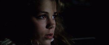Movie still from “Anguish” (1987), directed by Bigas Luna – A young girl looking at the camera with her eyes wide open; Close Up shot, High angle