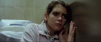 Movie still from “Anguish” (1987), directed by Bigas Luna – A woman is looking at the camera in the bathroom; Close Up shot, Low angle