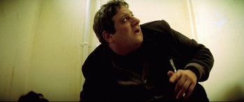 Movie still from “Anguish” (1987), directed by Bigas Luna – A person wearing a black jacket; Close Up shot, Low angle