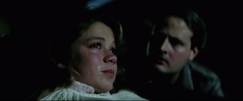 Movie still from “Anguish” (1987), directed by Bigas Luna – A young girl crying in front of another young man; Close Up shot, Over the shoulder angle