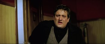 Movie still from “Anguish” (1987), directed by Bigas Luna – A person wearing a sweater and jacket; Close Up shot, Low angle