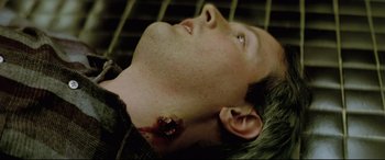 Movie still from “Anguish” (1987), directed by Bigas Luna – A young man with a wound on his face; Close Up shot, Overhead angle