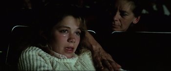 Movie still from “Anguish” (1987), directed by Bigas Luna – A young girl sitting next to an older woman; Close Up shot, High angle