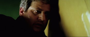 Movie still from “Anguish” (1987), directed by Bigas Luna – A person's face in a dark room; Close Up shot, Low angle