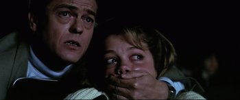 Movie still from “Anguish” (1987), directed by Bigas Luna – A man and a woman holding their hands over their mouths; Close Up shot, Low angle