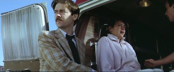 Movie still from “Anguish” (1987), directed by Bigas Luna – A man and a woman sitting in the back seat of a car; Medium shot, Low angle
