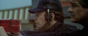 Movie still from “Anguish” (1987), directed by Bigas Luna – A person wearing a headset; Close Up shot, Low angle