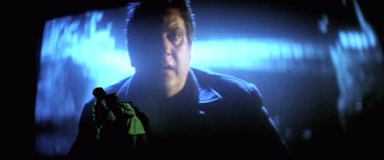 Movie still from “Anguish” (1987), directed by Bigas Luna – A man's face on a projector screen; Medium shot, Over the shoulder angle