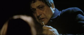 Movie still from “Anguish” (1987), directed by Bigas Luna – A person holding a pen in his mouth; Extreme Close Up shot, High angle