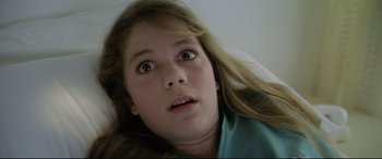 Movie still from “Anguish” (1987), directed by Bigas Luna – A young girl with long hair looking up at the sky; Close Up shot, Overhead angle