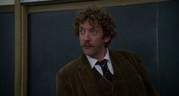 Movie still from “National Lampoon's Animal House” (1978), directed by John Landis – A man in a brown suit and a tie; Close Up shot, Low angle