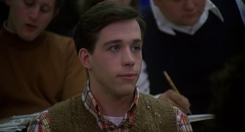 Movie still from “National Lampoon's Animal House” (1978), directed by John Landis – A young man in a plaid shirt and a brown vest; Close Up shot, High angle