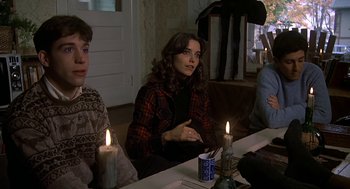 Movie still from “National Lampoon's Animal House” (1978), directed by John Landis – A group of people sitting around a table with candles; Medium shot, Over the shoulder angle