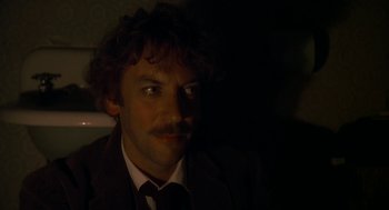 Movie still from “National Lampoon's Animal House” (1978), directed by John Landis – A man in a suit and tie with a mustache; Close Up shot, High angle