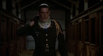 Movie still from “National Lampoon's Animal House” (1978), directed by John Landis – A man in a military uniform is adjusting his collar; Medium shot, Low angle