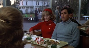 Movie still from “National Lampoon's Animal House” (1978), directed by John Landis – Two people sitting at a table with plates of food on it; Medium shot, Over the shoulder angle