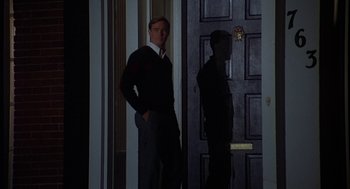Movie still from “National Lampoon's Animal House” (1978), directed by John Landis – A man standing in front of a black door at night; Medium shot, Low angle