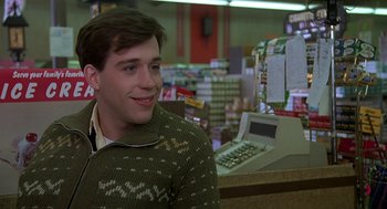 Movie still from “National Lampoon's Animal House” (1978), directed by John Landis – A young man sitting at a counter in front of a cash register; Close Up shot, Over the shoulder angle