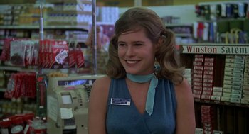 Movie still from “National Lampoon's Animal House” (1978), directed by John Landis – A woman in a blue dress smiling for the camera; Close Up shot, Low angle