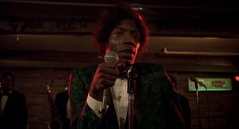 Movie still from “National Lampoon's Animal House” (1978), directed by John Landis – A man in a green jacket is holding a microphone; Close Up shot, Low angle