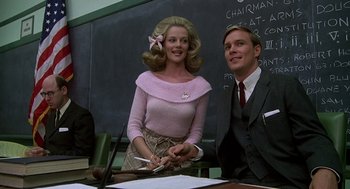 Movie still from “National Lampoon's Animal House” (1978), directed by John Landis – A man and a woman are sitting at a desk; Medium shot, Low angle