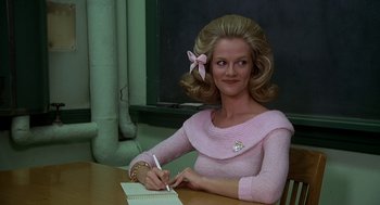 Movie still from “National Lampoon's Animal House” (1978), directed by John Landis – A woman in a pink sweater writing on a notepad; Medium shot, Low angle