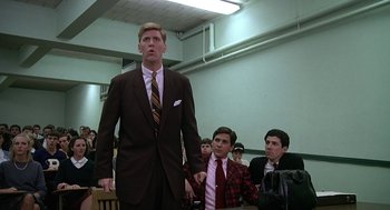 Movie still from “National Lampoon's Animal House” (1978), directed by John Landis – A man in a suit and tie standing in front of a group of people; Medium shot, Low angle