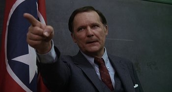 Movie still from “National Lampoon's Animal House” (1978), directed by John Landis – A man in a suit and tie holding a flag; Close Up shot, Low angle