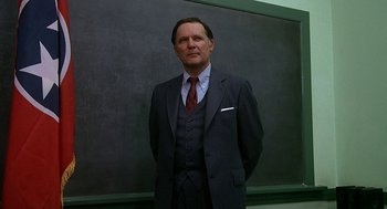 Movie still from “National Lampoon's Animal House” (1978), directed by John Landis – A man in a suit and tie standing in front of a chalkboard; Medium shot, Low angle