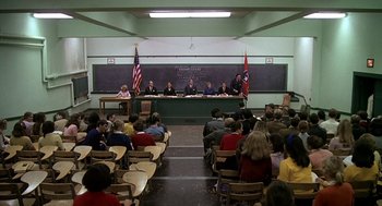 Movie still from “National Lampoon's Animal House” (1978), directed by John Landis – A group of people sitting at a table in front of a chalkboard; Wide shot, High angle