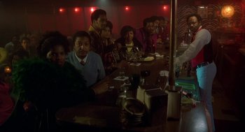 Movie still from “National Lampoon's Animal House” (1978), directed by John Landis – A group of people sitting at a table in a room; Wide shot, High angle