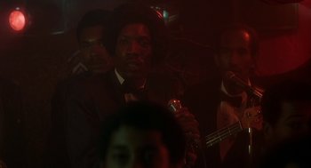 Movie still from “National Lampoon's Animal House” (1978), directed by John Landis – A group of men standing next to each other in a dark room; Close Up shot, Over the shoulder angle