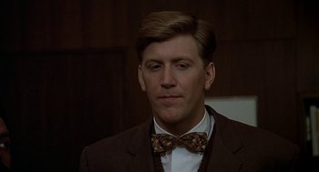 Movie still from “National Lampoon's Animal House” (1978), directed by John Landis – A man wearing a suit and bow tie; Close Up shot, Over the shoulder angle