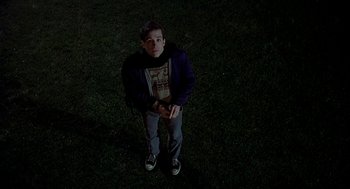 Movie still from “National Lampoon's Animal House” (1978), directed by John Landis – A man standing in the grass at night; Wide shot, Overhead angle