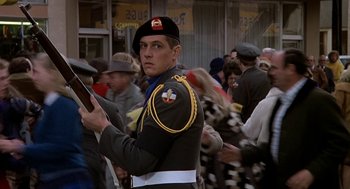 Movie still from “National Lampoon's Animal House” (1978), directed by John Landis – A man in a military uniform is holding a tablet; Medium shot, Over the shoulder angle