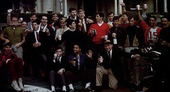 Movie still from “National Lampoon's Animal House” (1978), directed by John Landis – A group of men sitting and standing on the ground; Wide shot, High angle